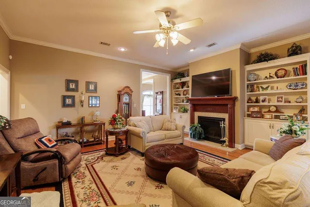 a living room with furniture a flat screen tv and a fireplace