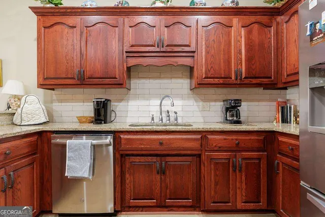 a kitchen with granite countertop wooden cabinets a sink and dishwasher