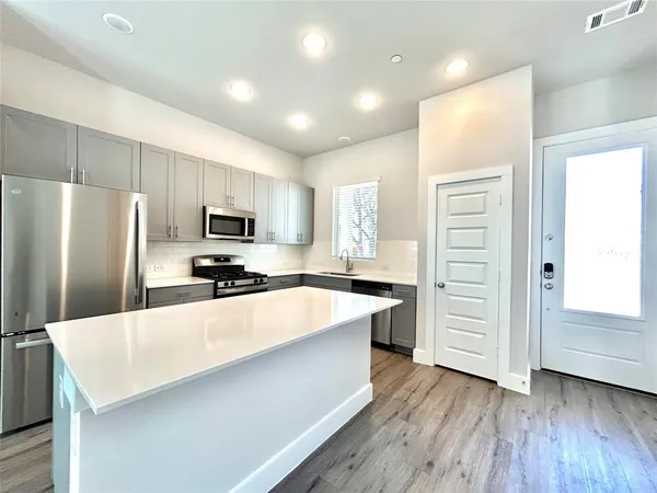 a bathroom with a granite countertop sink a toilet a mirror and shower