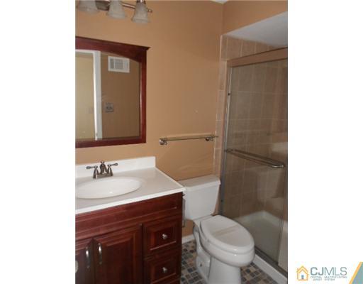 200 Portland Road, Unit D8 Highlands, NJ 07732 - Photo 7 of 10 a bathroom with a toilet a sink and mirror