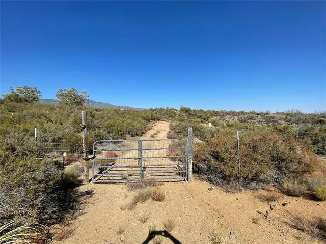 a view of a yard with wooden fence