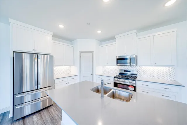 a kitchen with a sink stove and cabinets