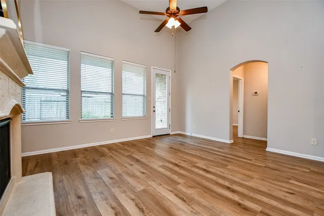 a view of an empty room with window and a chandelier fan