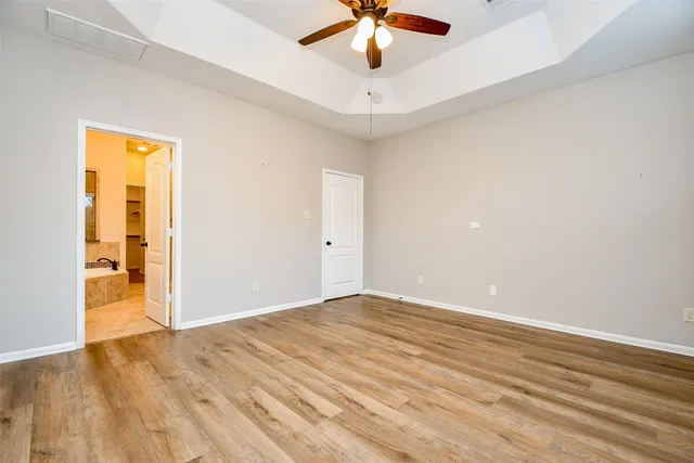 a spacious bathroom with a granite countertop double vanity sink a mirror and a bathtub