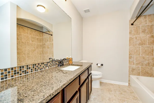 an empty room with window and ceiling fan