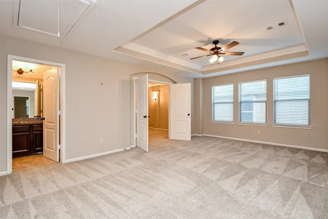 an empty room with closet and a ceiling fan