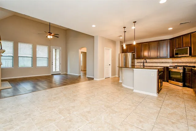 a kitchen with stainless steel appliances granite countertop a refrigerator a sink and a oven