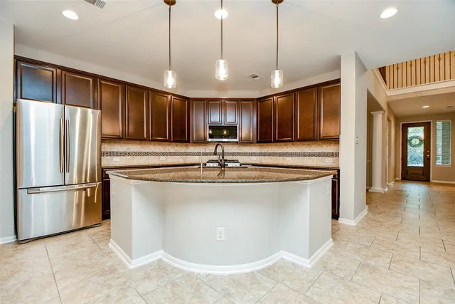 a kitchen with granite countertop a sink a center island and windows