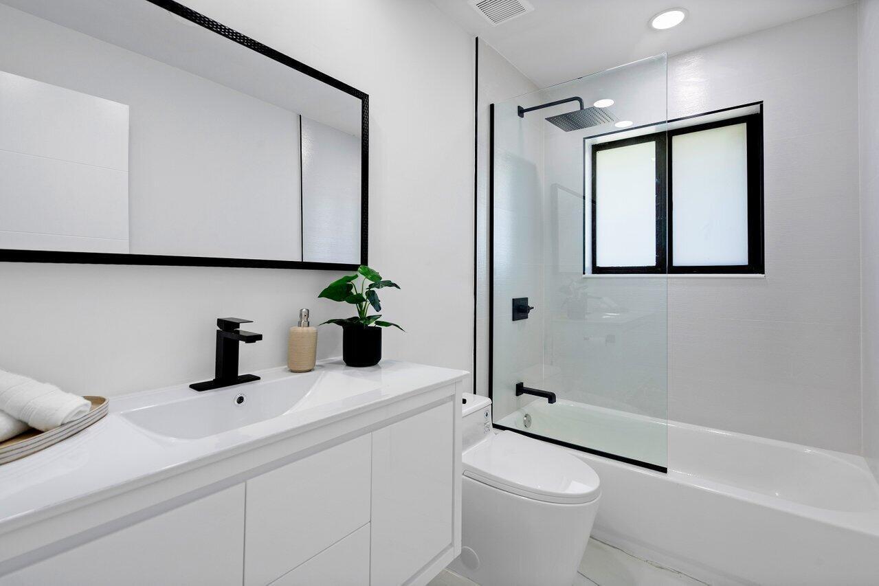 1200 Southwest 8th Street Boca Raton, FL 33486 - Photo 21 of 42 a bathroom with a toilet a sink and mirror
