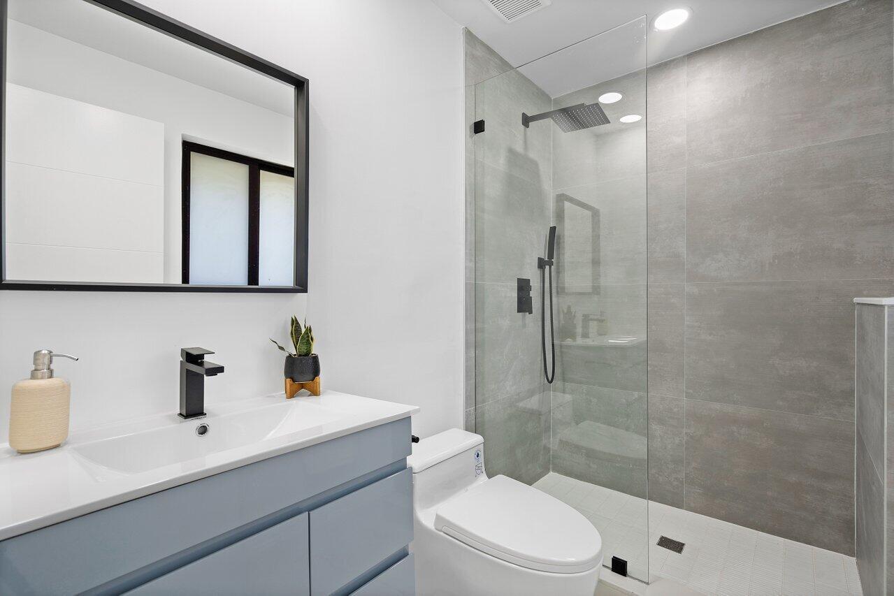 1200 Southwest 8th Street Boca Raton, FL 33486 - Photo 23 of 42 a bathroom with a sink a toilet a mirror and shower