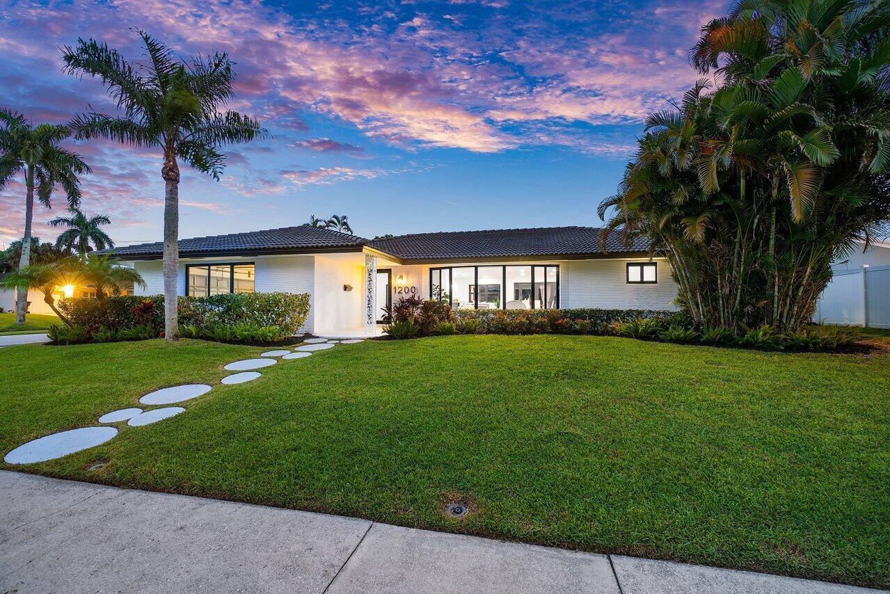 1200 Southwest 8th Street Boca Raton, FL 33486 - Photo 35 of 42 a front view of a house with a garden and yard