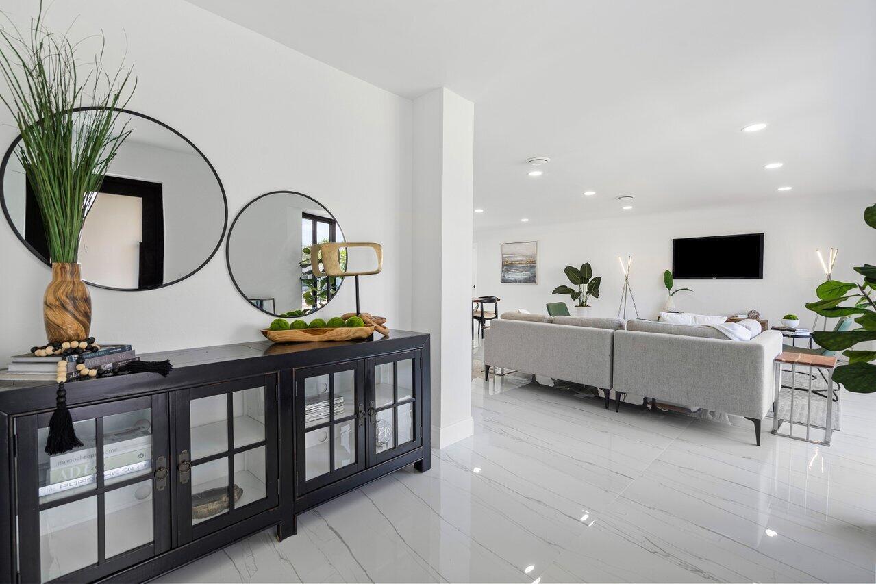 1200 Southwest 8th Street Boca Raton, FL 33486 - Photo 5 of 42 a living room with furniture a mirror and a flat screen tv
