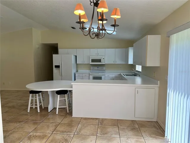 a kitchen with cabinets and chairs