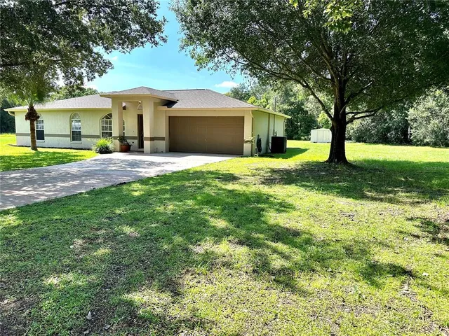 a front view of a house with a yard and trees