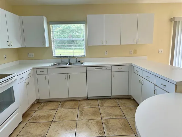 a kitchen with a sink window and cabinets