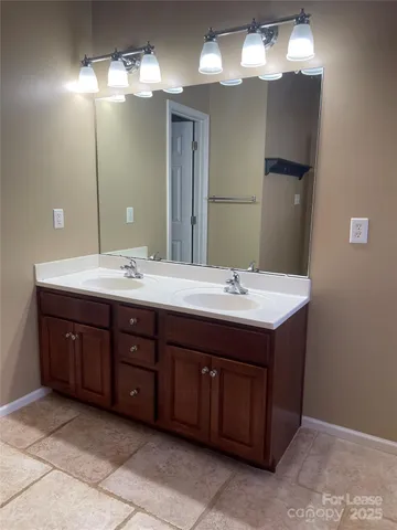 a bathroom with a double vanity sink and a mirror