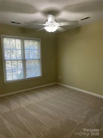en empty room with windows and chandelier