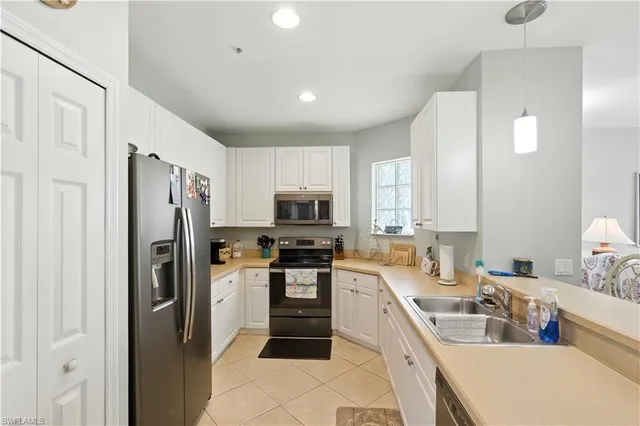 a large kitchen with a refrigerator a sink a stove a microwave and cabinets