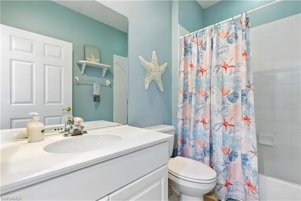 a bathroom with a sink a toilet and shower curtain