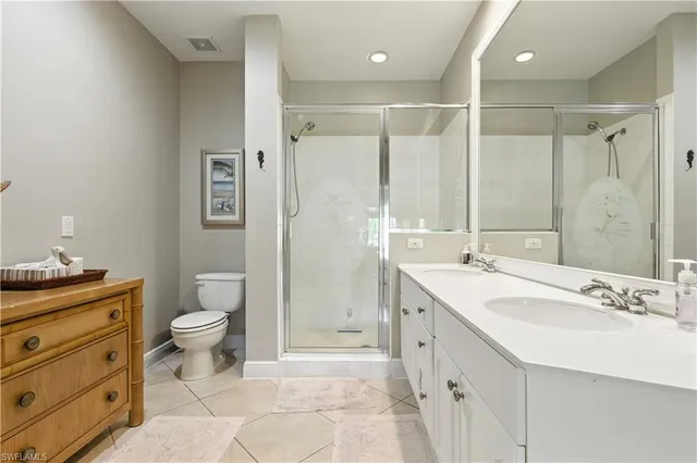 a bathroom with a double vanity sink toilet and shower