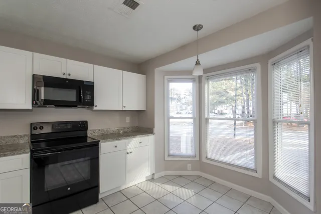 a kitchen with a stove a sink and a microwave