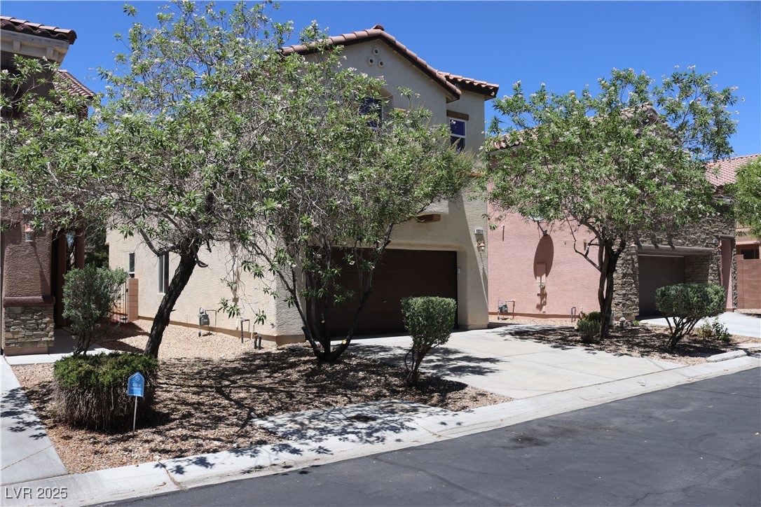 10211 Glimmering Star Drive Las Vegas, NV 89178 - Photo 33 of 33 View of front of home with an attached garage, a tile roof, concrete driveway, and stucco siding