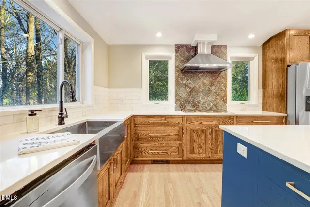 a kitchen with stainless steel appliances kitchen island granite countertop a sink and a stove