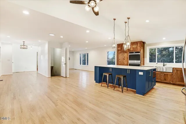 a spacious bathroom with a granite countertop sink a large mirror and a bathtub next to a window