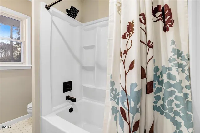 an empty room with wooden floor and fan