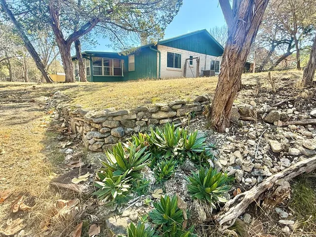 a brick house with trees in front of it