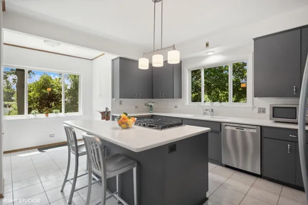 a kitchen with a stove a sink a dining table and chairs