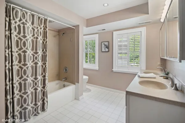 a bathroom with a tub sink and mirror