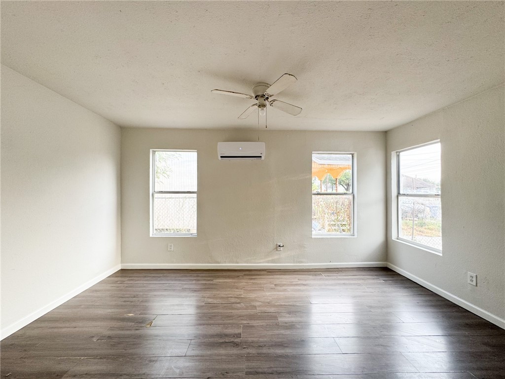 1108 14th Street Corpus Christi, TX 78404 - Photo 3 of 11 an empty room with wooden floor and windows