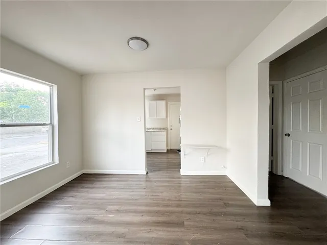 a view of an empty room and wooden floor and a window