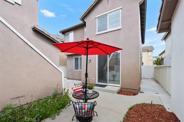 a patio with a table and chairs under an umbrella