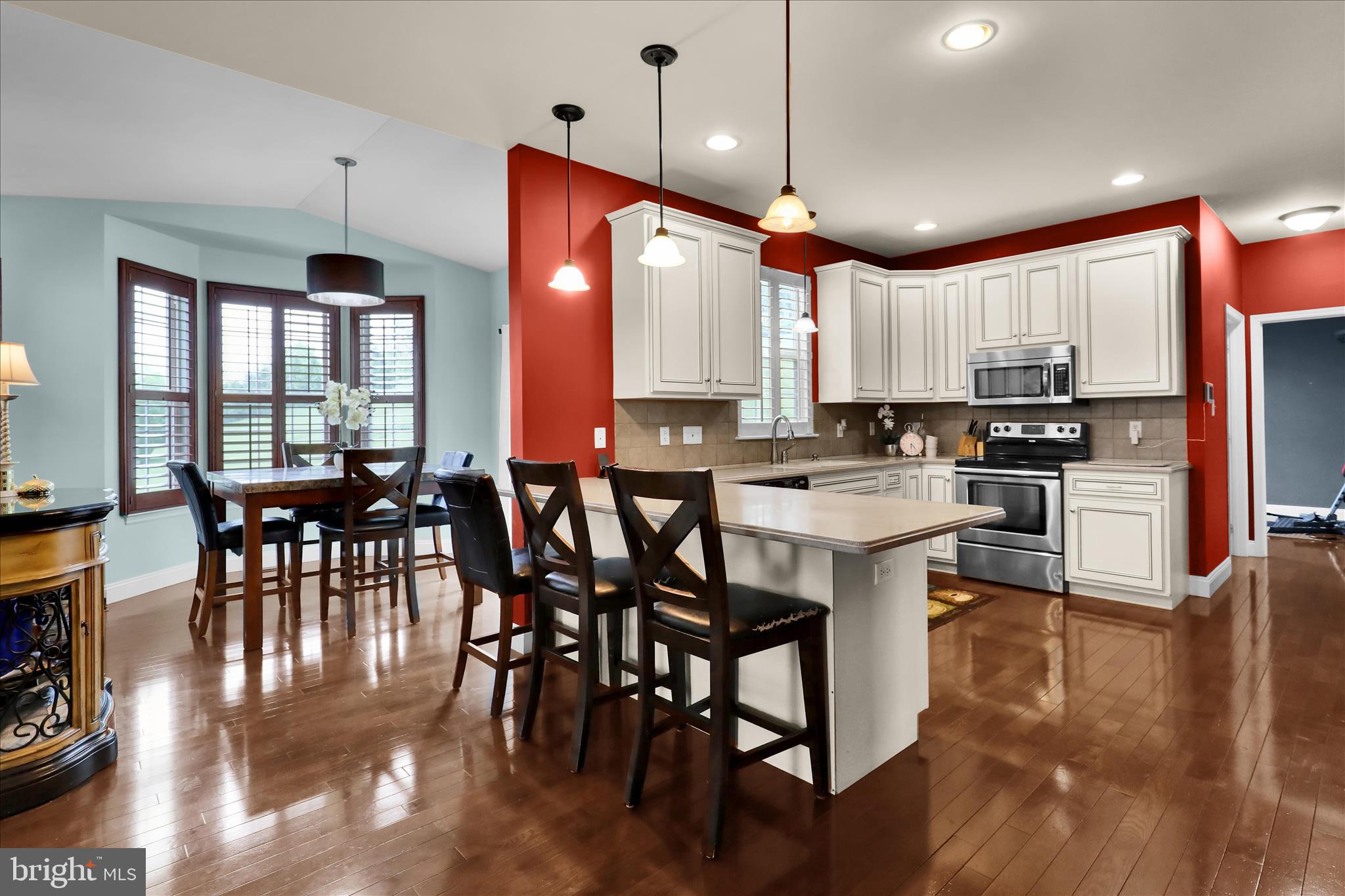 121 Great Bend Way Sinking Spring, PA 19608 - Photo 14 of 59 a kitchen with stainless steel appliances granite countertop a stove a refrigerator a kitchen island with a dining table and chairs