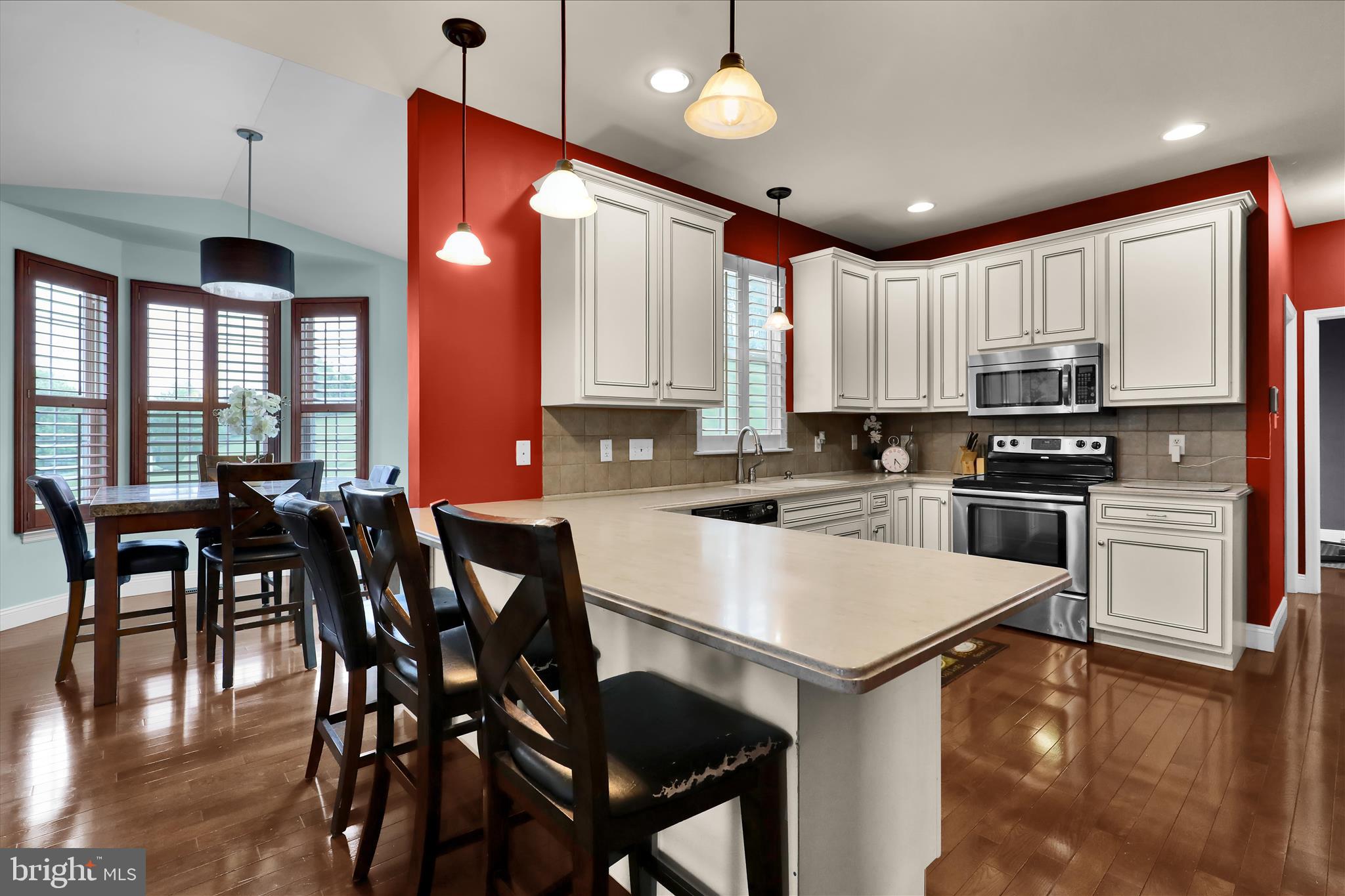 121 Great Bend Way Sinking Spring, PA 19608 - Photo 16 of 59 a kitchen with stainless steel appliances granite countertop a stove a refrigerator a kitchen island a sink white cabinets and wooden floor