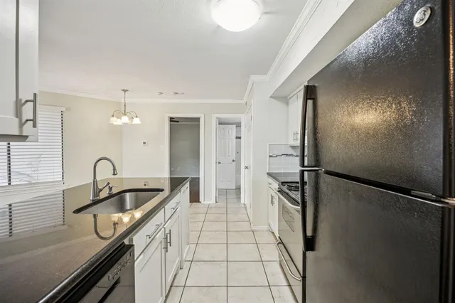 a kitchen with a sink a refrigerator and cabinets
