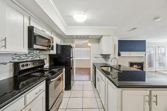 a kitchen with granite countertop a sink stainless steel appliances and cabinets