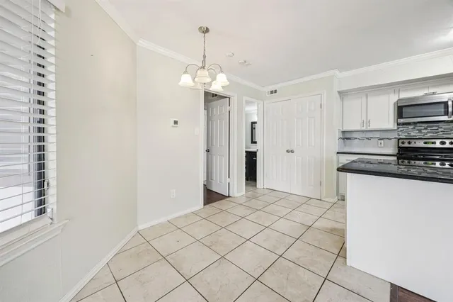 a view of a kitchen with a sink and dishwasher a refrigerator with white cabinets