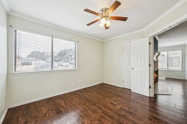 a view of a big room with wooden floor and a chandelier fan