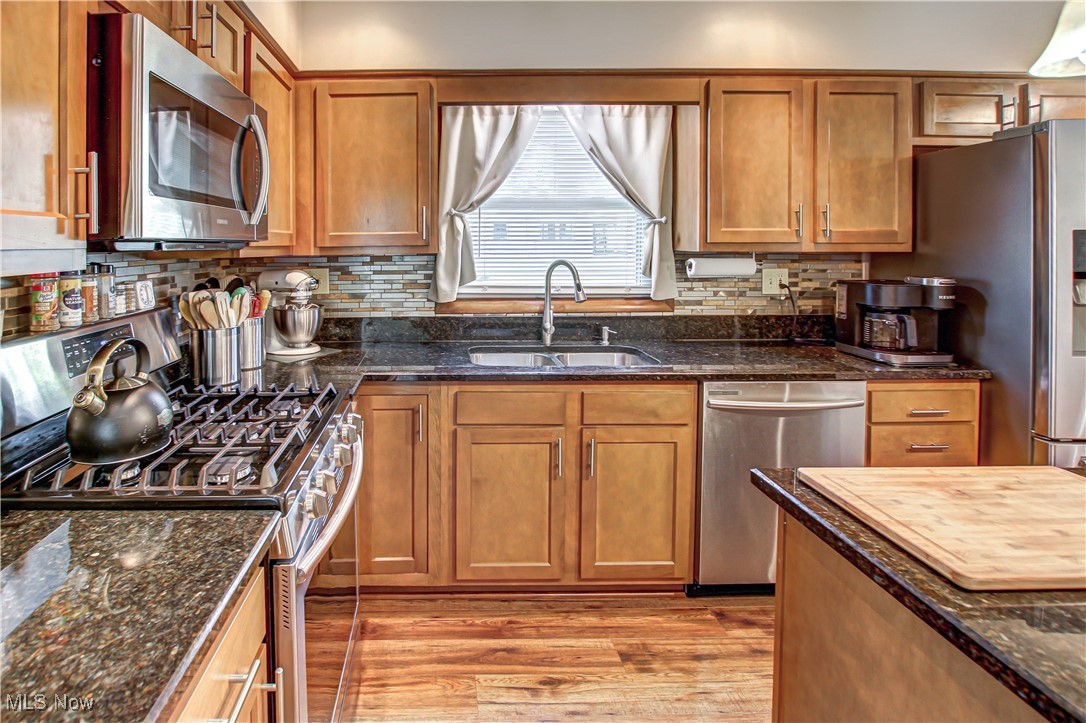 4234 Grafton Road Brunswick, OH 44212 - Photo 4 of 40 Kitchen featuring sink, stainless steel appliances, light hardwood / wood-style floors, and dark stone counters
