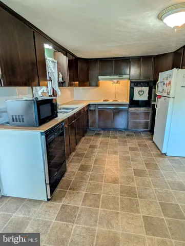 a kitchen with stainless steel appliances a sink a stove top oven a counter space and cabinets