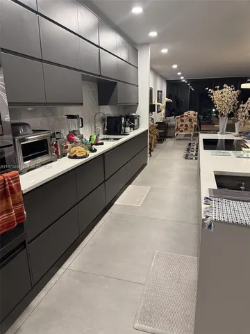 a kitchen with stainless steel appliances kitchen island granite countertop a sink and cabinets