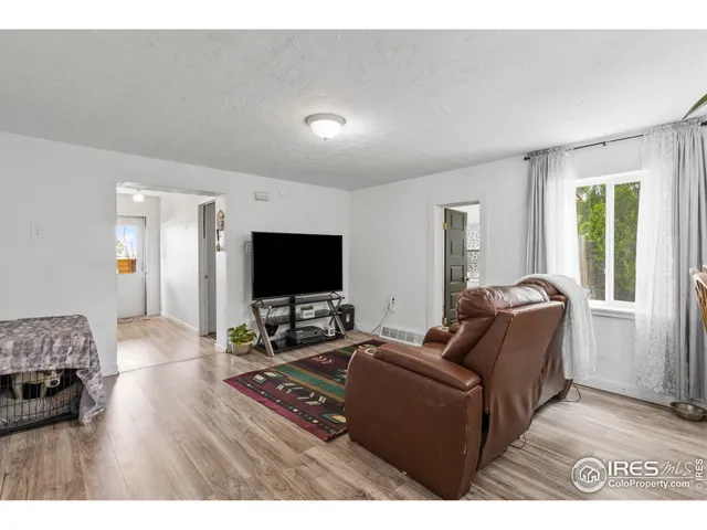 a bedroom with a bed and a flat tv screen on dresser