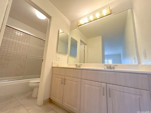 a bathroom with a double vanity sink toilet and shower