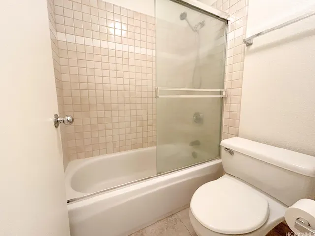 a white toilet and tub next to a bathroom sink