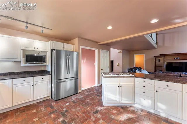 a kitchen with granite countertop a sink stove and refrigerator