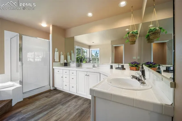 a bathroom with a sink a bathtub and next to a window