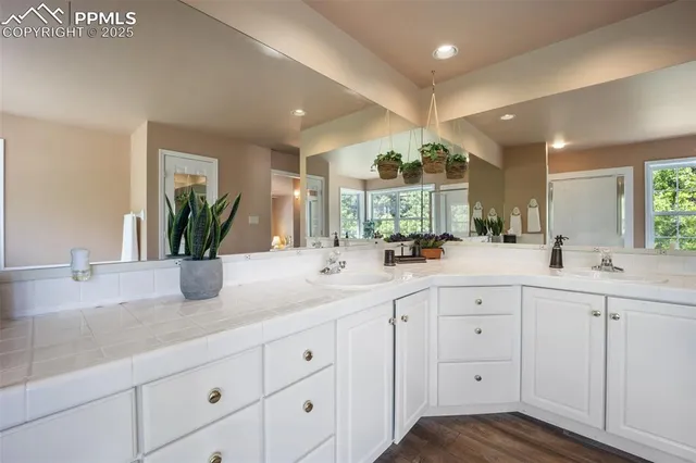 a dining room with wooden floor a chandelier a wooden table and chairs